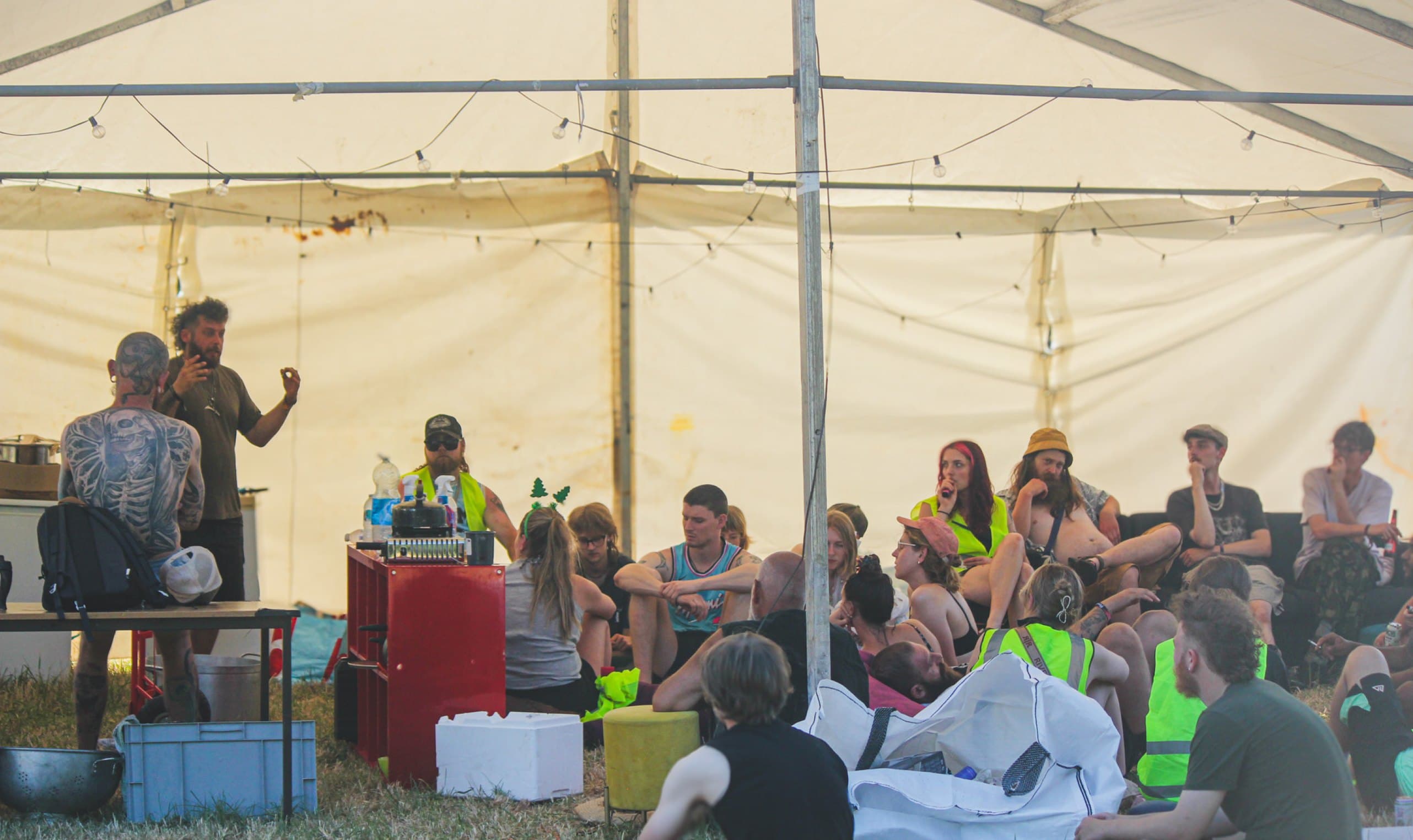 The Saturday morning crew briefing under the big top, the whole team sitting on the grass.