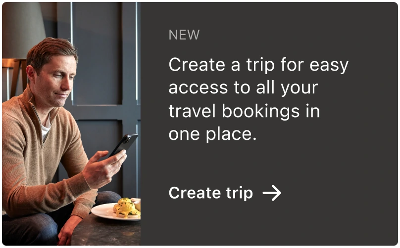 A promotional card: “Create a trip for easy access to all your travel bookings in one place”, over a photograph of a traveller with a phone.