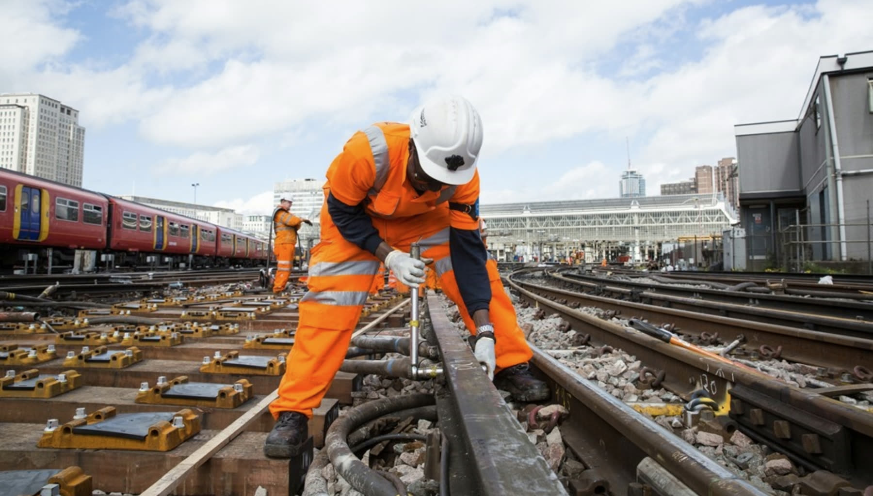 Rail workers laying track beside a commuter line